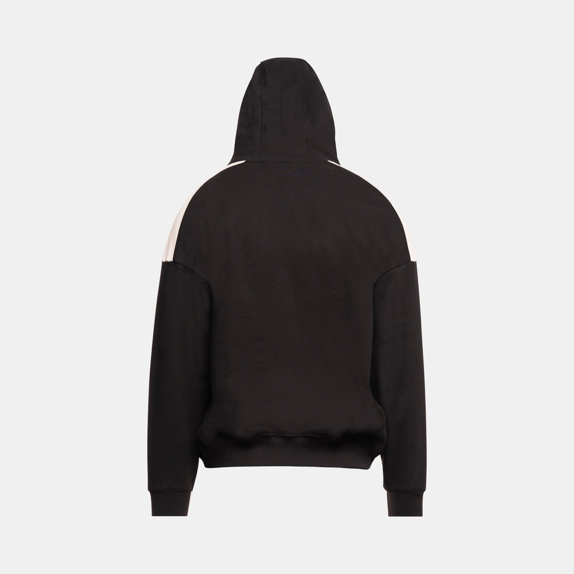 A black pullover hoodie shown from the back with hood up, featuring contrasting light beige panels on the upper front shoulders, set against a plain light gray background.
