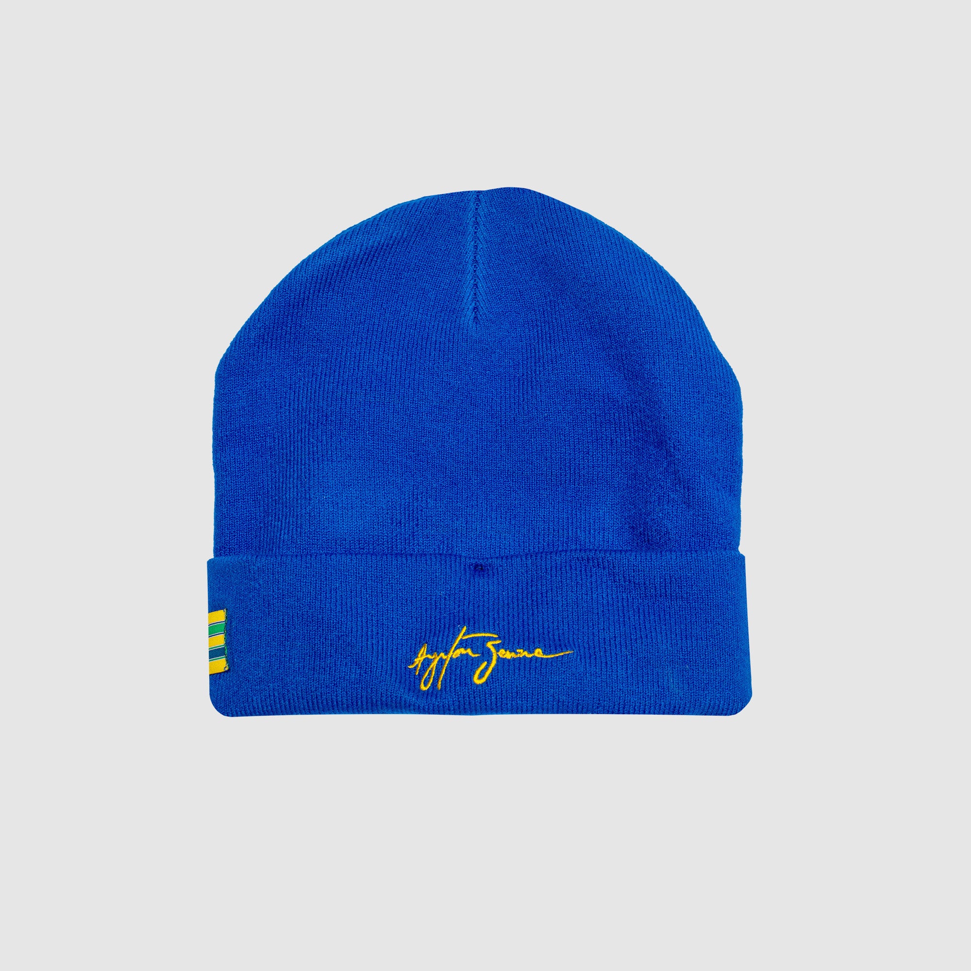 Blue beanie with yellow logo on a light gray background Aryton Senna signature on the back,