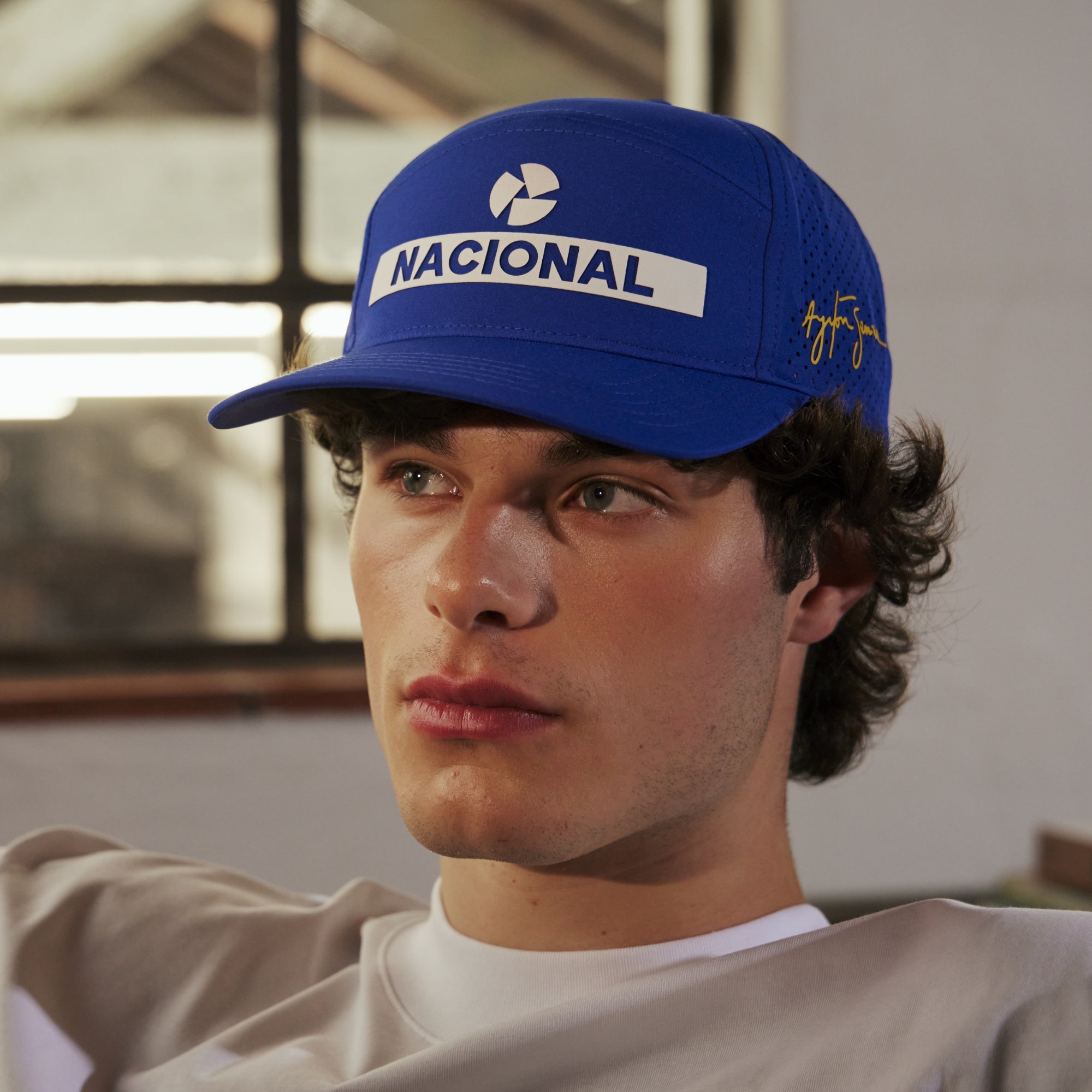 Person wearing a blue cap with 'NACIONAL' branding in an indoor setting