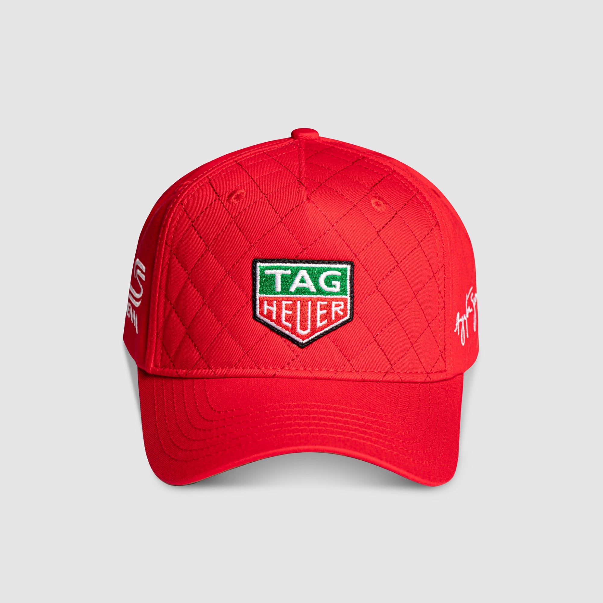 Red quilted cap with Tag Heuer & Senna logo on a light gray background