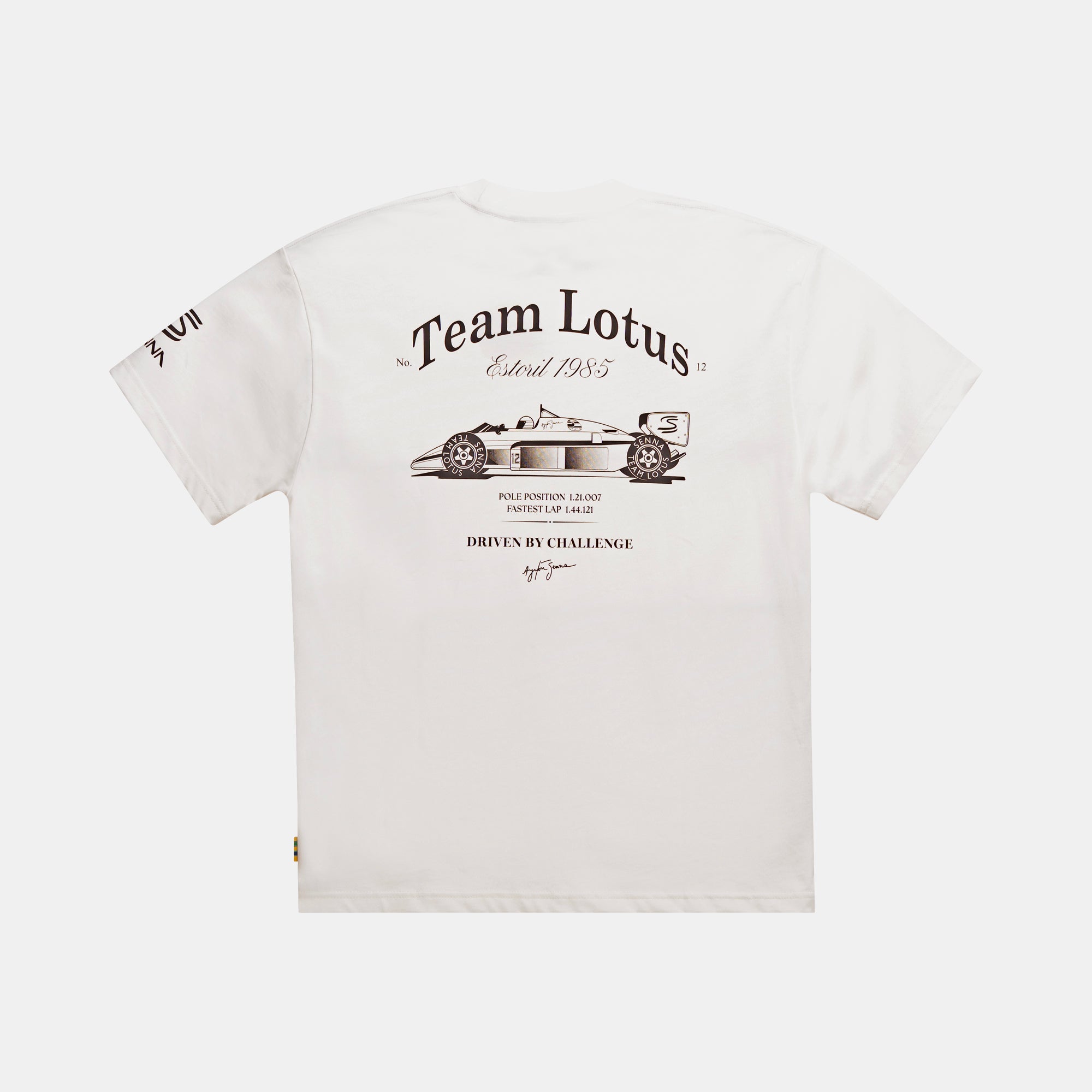 A cream color short-sleeve t-shirt shown from the back, featuring a black illustrated graphic print of a Formula 1 race car and 'Team Lotus' text on the top back, with additional text including Ayrton Senna Signature and a Senna brand logo on the left sleeve.