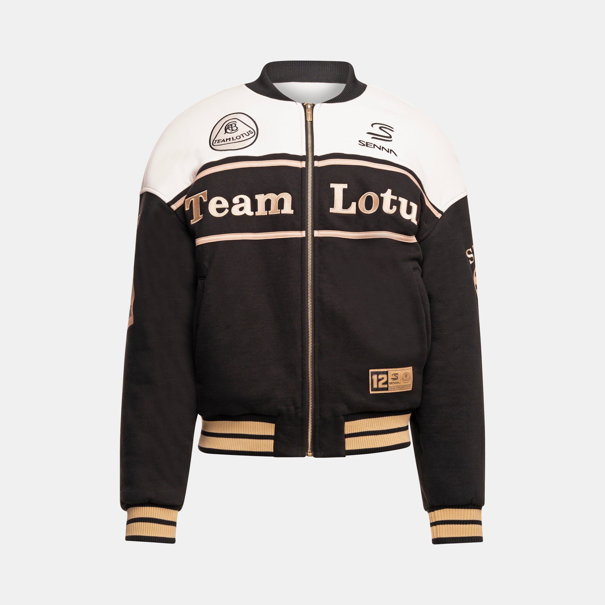 A black and white color-blocked varsity-style jacket with gold accents, featuring 'Team Lotus' printed across the chest, and embroidered logos of Team Lotus and Senna. Thick gold striped details appear on the sleeve cuffs and fitted waist.