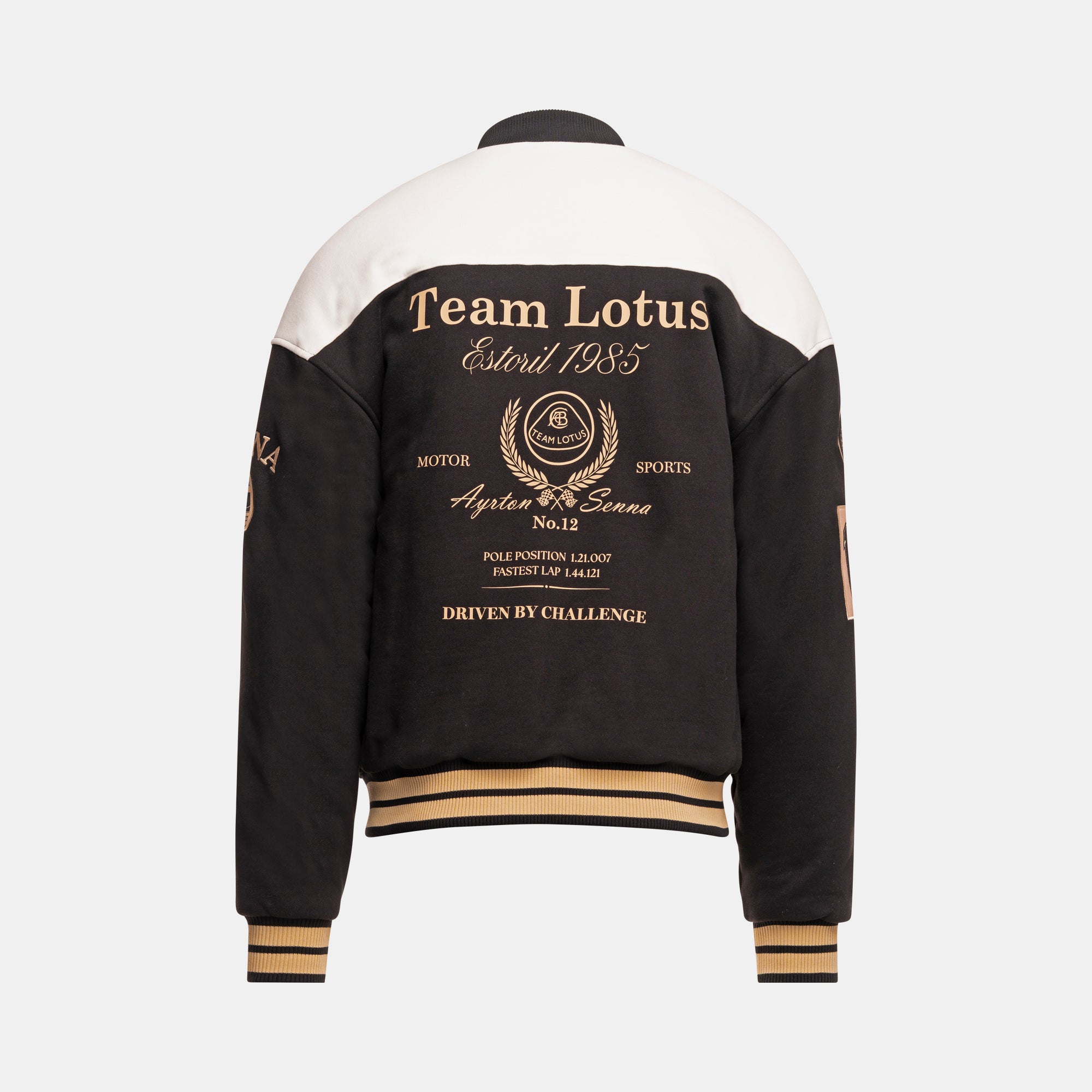 Back view of a varsity-style jacket with a black and white color-blocked design, featuring gold and black text and graphics on the back, including 'Team Lotus Estoril 1985' and a wreath crest emblem with 'Ayrton Senna'.