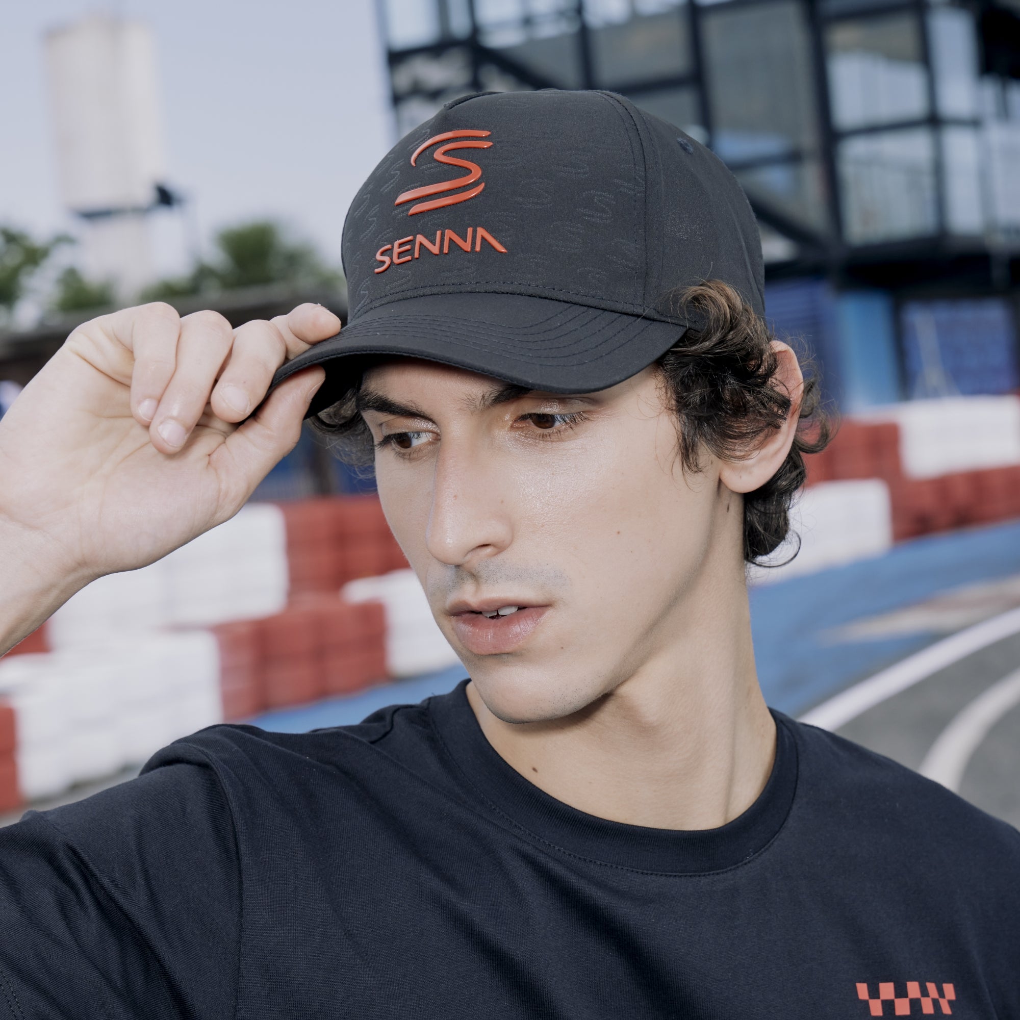 Person wearing a black cap with 'SENNA' branding in an outdoor setting